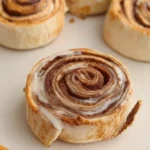 Tortilla Cinnamon Rolls on a plate with glaze