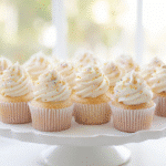 a bright kitchen with a tray of freshly baked vanilla cupcakes