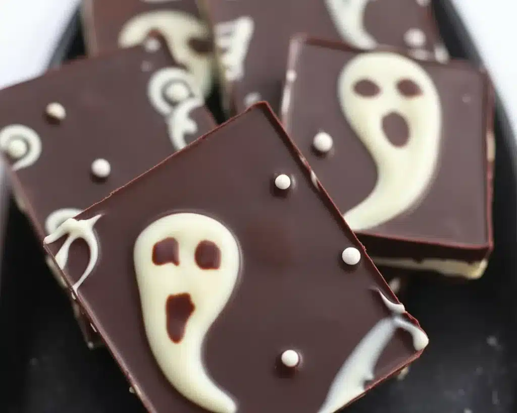 Halloween candy bark with white chocolate ghosts and colorful candy toppings.