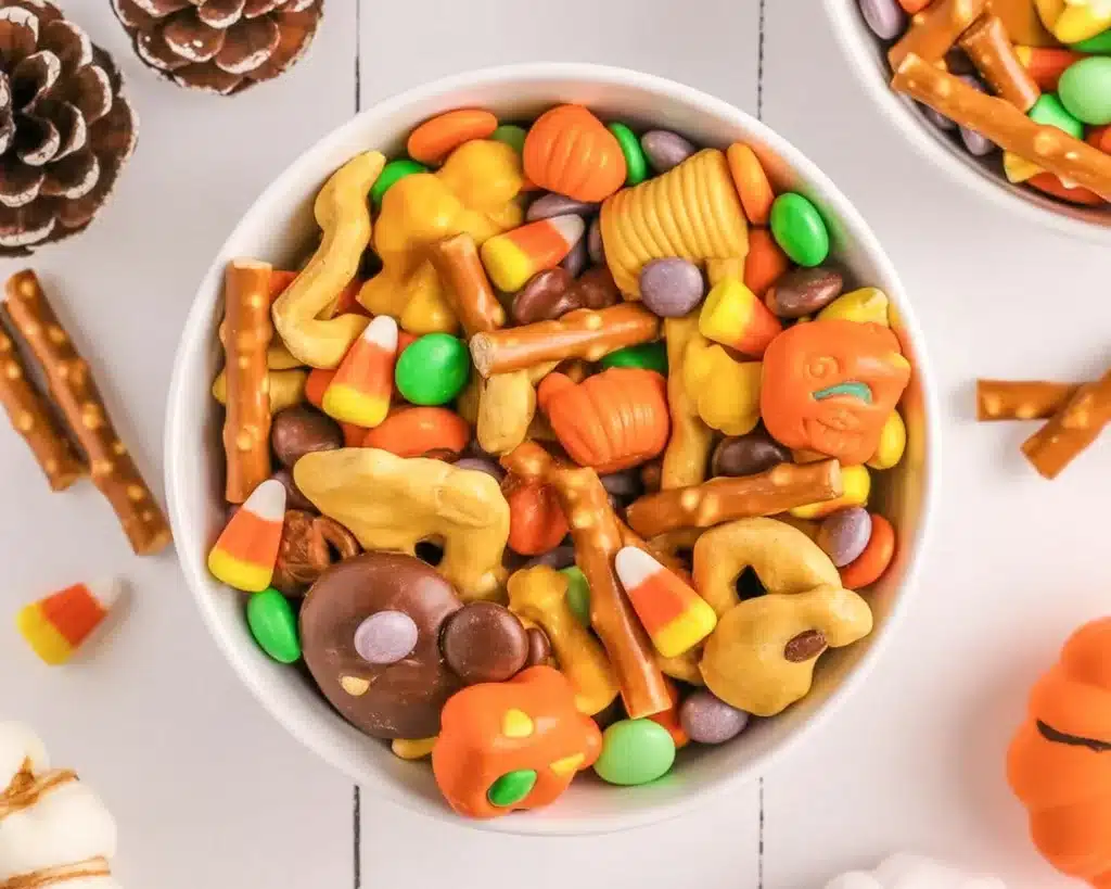 Colorful Halloween candy trail mix with Chex, pretzels, and seasonal candies.