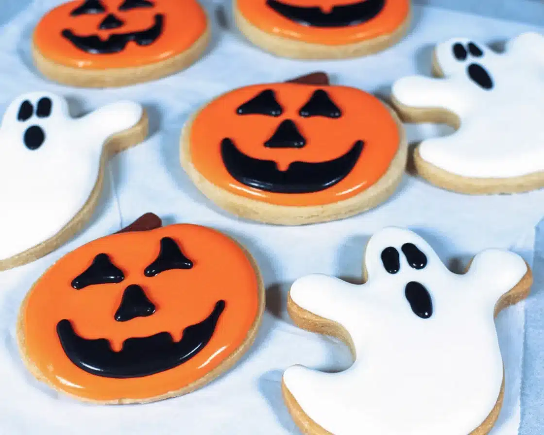 Colorful Vegan Halloween Cookies shaped like spooky characters and decorated for Halloween.