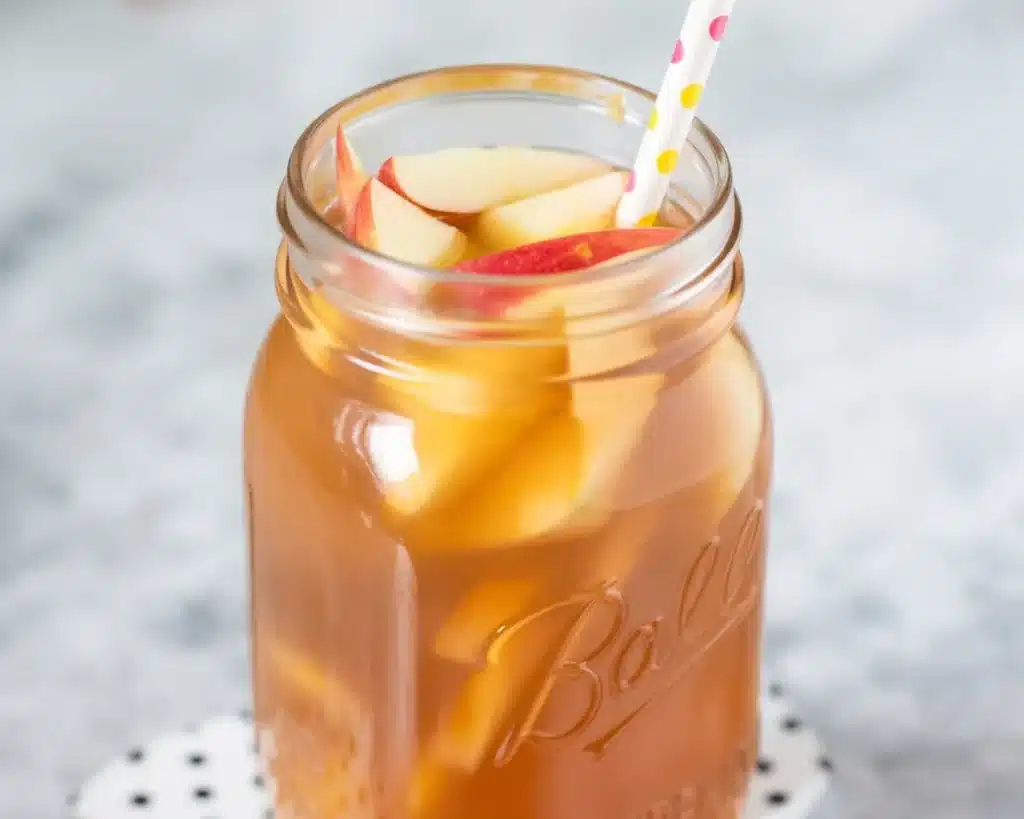 A refreshing glass of Caramel Apple Sangria with apples, caramel, and white wine.