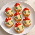 Crispy baguette bites topped with cream cheese, cherry tomatoes, and dill on a platter.