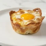 Crispy ham and cheese breakfast cups filled with gooey eggs, perfect for kids