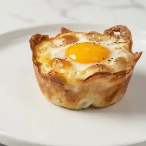 Crispy ham and cheese breakfast cups filled with gooey eggs, perfect for kids