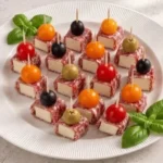 Delicious salami and cream cheese skewers with cherry tomatoes on a platter