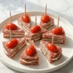 Low-carb party appetizer with salami, cream cheese, and olives on a platter