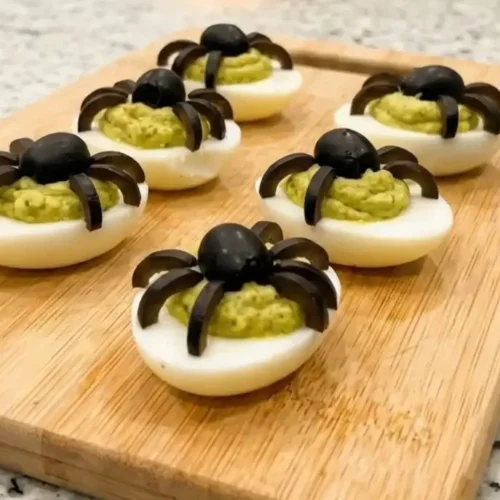 Spooky deviled eggs decorated to look like spider eggs for Halloween