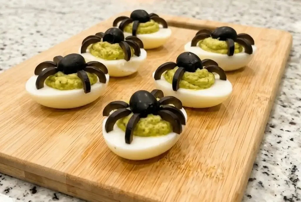 Spooky deviled eggs decorated to look like spider eggs for Halloween